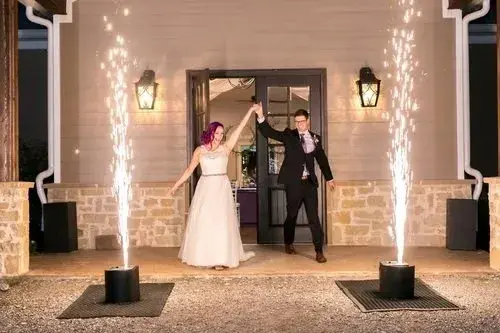 Newlyweds making their entrance between cold spark fountains