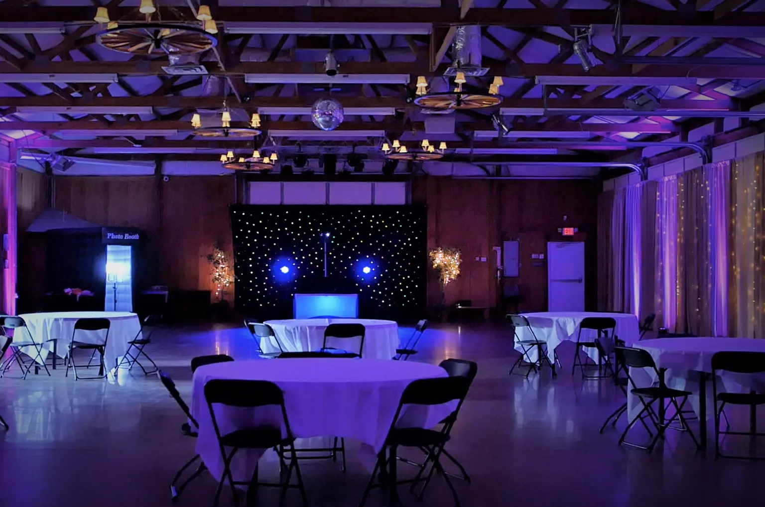 Wedding reception room with purple uplighting and warm string lights